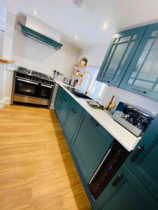 Il comprend une cuisine avec des placards bleus et du parquet. dans l'établissement Apartment22. A stylish and spacious Apartment in the heart of Historic Market town of Beverley., à Beverley