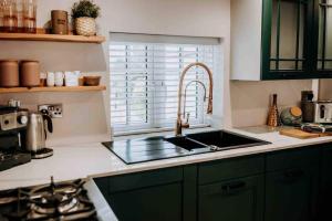 a kitchen with green cabinets and a sink and a window at Apartment22. A stylish and spacious Apartment in the heart of Historic Market town of Beverley. in Beverley +3 photos