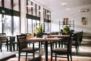 - une salle à manger avec des tables, des chaises et des fenêtres dans l'établissement Hotel Čatež - Terme Čatež, à Čatež ob Savi