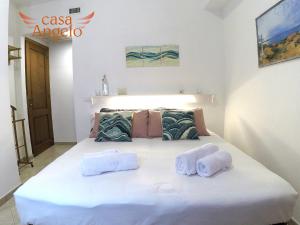 una camera da letto con un letto e asciugamani di Casa Angelo B&B a Calasetta
