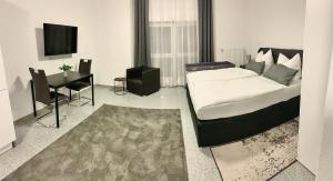 a bedroom with a bed and a desk and a television at Pent - Aparthotel Crailsheim in Crailsheim