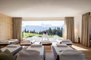 a woman is sitting in a room with mattresses at Hotel Tann in Collalbo