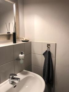 a white bathroom with a sink and a mirror at 1-2 Zimmer in alter Villa - Netflix+Homeoffice in Bergkamen
