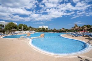 una grande piscina con sedie e ombrelloni di Club Cala Domingos a Calas de Mallorca