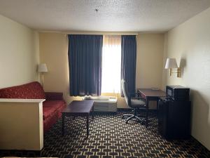 a hotel room with a bed and a desk and a window at Budgetel Inns & Suites in Fairfield