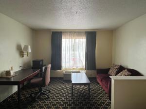 Fairfield的住宿－Budgetel Inns & Suites，酒店客房设有一张桌子、一张沙发和一个窗口。