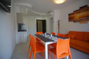 uma sala de jantar com uma mesa e cadeiras laranja em APPARTAMENTO NUOVO CENTRALISSIMO 150 MT DAL MARE em Lido di Jesolo