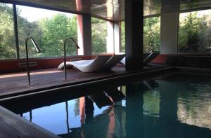 Hotel Spa La Central - Adults Only في ماسانيت دي كابرينيس: حمام سباحة مع صف من المغاسل في المنزل