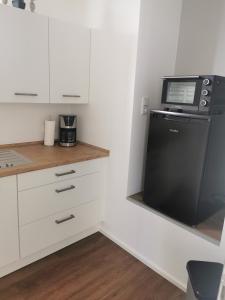 a kitchen with a black refrigerator and a microwave at Ferienwohnung am Felsenkeller in Ebrach
