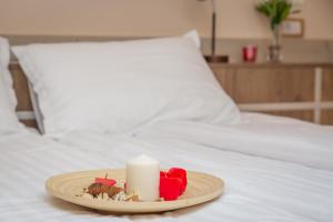 a candle on a plate on a bed at HARIZMA 013 in Kovin