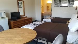 a hotel room with two beds and a table at Travelers Inn & Suites in Sumter