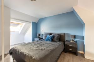 Un dormitorio con una cama con una pared de acento azul en SPACIEUX CHIC Confort Parcs et Thermes en Vichy