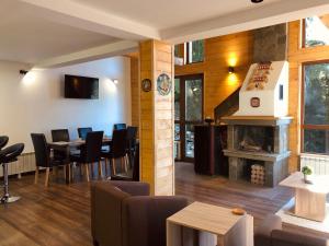 a restaurant with a fireplace and tables and chairs at Villa Mischa in Grashtitsa