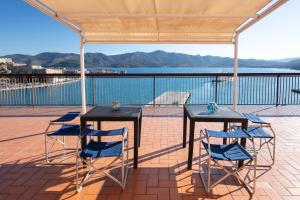 due tavoli e sedie su un patio con vista sull'acqua di Dal Sandro B&B a Portoferraio