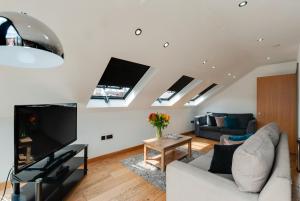 a living room with a couch and a tv at Base Serviced Apartments - Sir Thomas Street in Liverpool