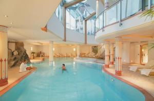 una piscina in un hotel con una persona in acqua di Hotel Col Alto a Corvara in Badia