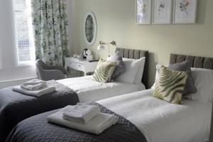 dos camas sentadas una al lado de la otra en una habitación en The Milford Arms, en Hounslow