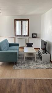 a living room with a blue couch and a table at ARAKAZA- Bolbec- WIFI GRATUIT in Bolbec