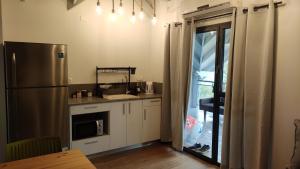 een keuken met een roestvrijstalen koelkast en een tafel bij יערה בכפר קרוב לנחל in Bet Hillel +6 foto's