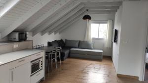 een keuken en een woonkamer met een bank en een tafel bij יערה בכפר קרוב לנחל in Bet Hillel