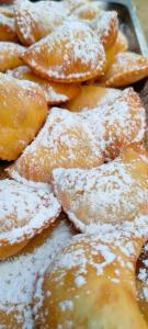 a bunch of donuts covered in powdered sugar at Villa Calipso in Mondello