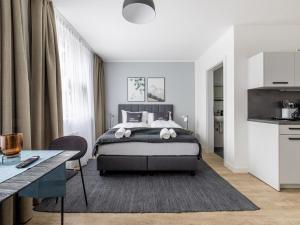 um quarto com uma cama grande e uma mesa em limehome Klagenfurt Karfreitstraße em Klagenfurt