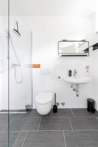 a bathroom with a toilet and a sink at limehome Klagenfurt Karfreitstraße in Klagenfurt