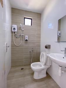 a bathroom with a toilet and a sink at Hotel Decentraland Kuala Terengganu in Kuala Terengganu