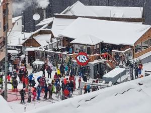 una folla di persone che camminano in una stazione sciistica nella neve di Pensiunea LUCA Straja a Straja