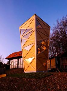 ein würfelförmiges Gebäude vor einem Gebäude in der Unterkunft Hunting Tower Na Škaluc in Šentrupert