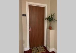 a wooden door with a potted plant in a hallway at Doncaster City Centre Deluxe Whole Apartment sleeps 4 D19 in Doncaster +9 photos
