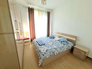 um quarto com uma cama com lençóis azuis e brancos em Appartment Lura 3 em Durrës