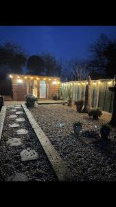 un patio trasero por la noche con luces en una casa en Deer Lodge, en Thornton Curtis