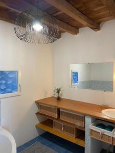 ein Bad mit einem Waschbecken und einem Spiegel in der Unterkunft Maison La Reine in La reine
