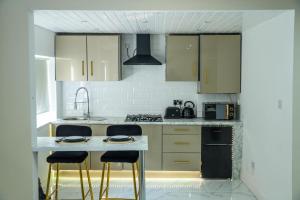 Una cocina con gabinetes blancos y electrodomésticos negros. en 1 Bed House - Sleeps 2 - Parking - Wifi, en Bradford 4 fotos más