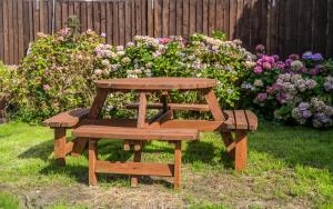 una mesa de picnic y un banco en un patio con flores en 1 Bed House - Sleeps 2 - Parking - Wifi, en Bradford