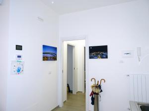 un corridoio con pareti bianche e quadri alle pareti di appartamento fronte mare a Pescara