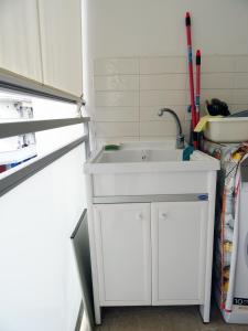 un lavandino bianco in una cucina accanto a un frigorifero di appartamento fronte mare a Pescara