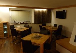 a restaurant with tables and chairs in a room at Pension Mühle in Zell am See