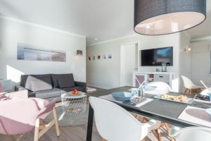 ein Wohnzimmer mit Tisch und Stühlen und einer Couch in der Unterkunft Apartmenthaus "Kiki", Wohnung "Traumbude" in Heiligenhafen