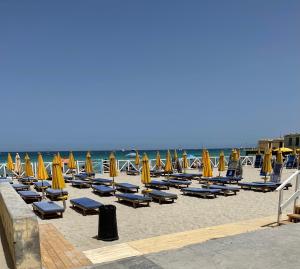 a beach with chairs and umbrellas and the ocean at Villa Calipso in Mondello
