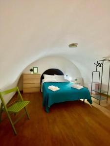 a bedroom with a blue bed and a green chair at Mariposa in Telese