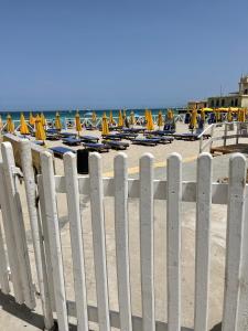 a white fence on the beach with chairs and umbrellas at Villa Calipso in Mondello