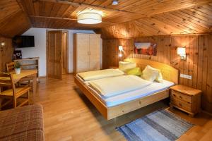シュラートミンクにあるWeitgasserhofの木製の部屋に大型ベッドが備わるベッドルーム1室が備わります。