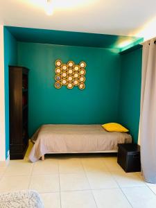 una camera da letto con un letto e una parete verde di Gites Le Patio34 a Lavérune Altre 35 foto