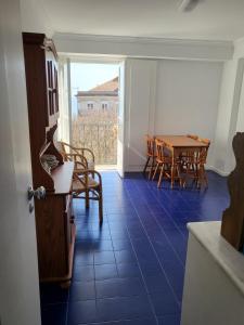 a room with a table and chairs and a blue tile floor at Pilar - Alfama River View in Lisbon