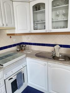 a kitchen with white cabinets and a sink at Pilar - Alfama River View in Lisbon