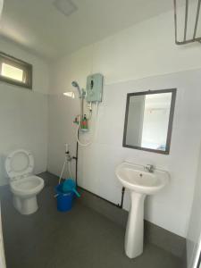 a bathroom with a toilet and a sink and a mirror at LeThuHouse in Melaka
