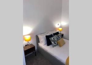 a bedroom with a bed with two lamps on it at Doncaster City Centre Deluxe Whole Apartment sleeps 4 D41 in Doncaster +10 photos