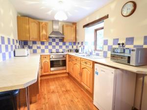 a kitchen with wooden cabinets and a counter top at Yr Hen Felin in Oswestry